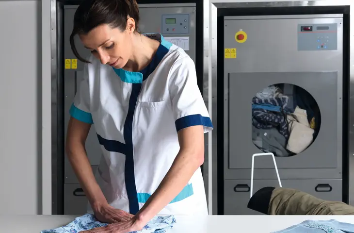 Elis Care homes' staff member folding resident's clothing 