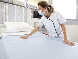 Nurse making up hospital bed