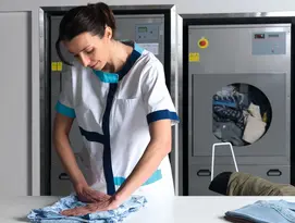 Elis Care homes' staff member folding resident's clothing 